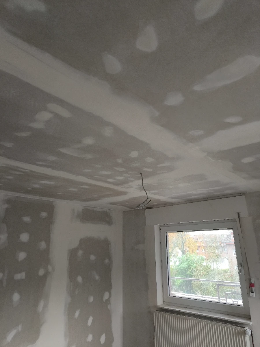 Spachtelarbeiten an Decke und Wänden mit vorbereiteter Trockenbauoberfläche und losem Kabel